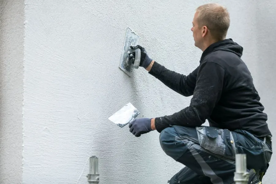 Render being applied to the exterior wall of a house